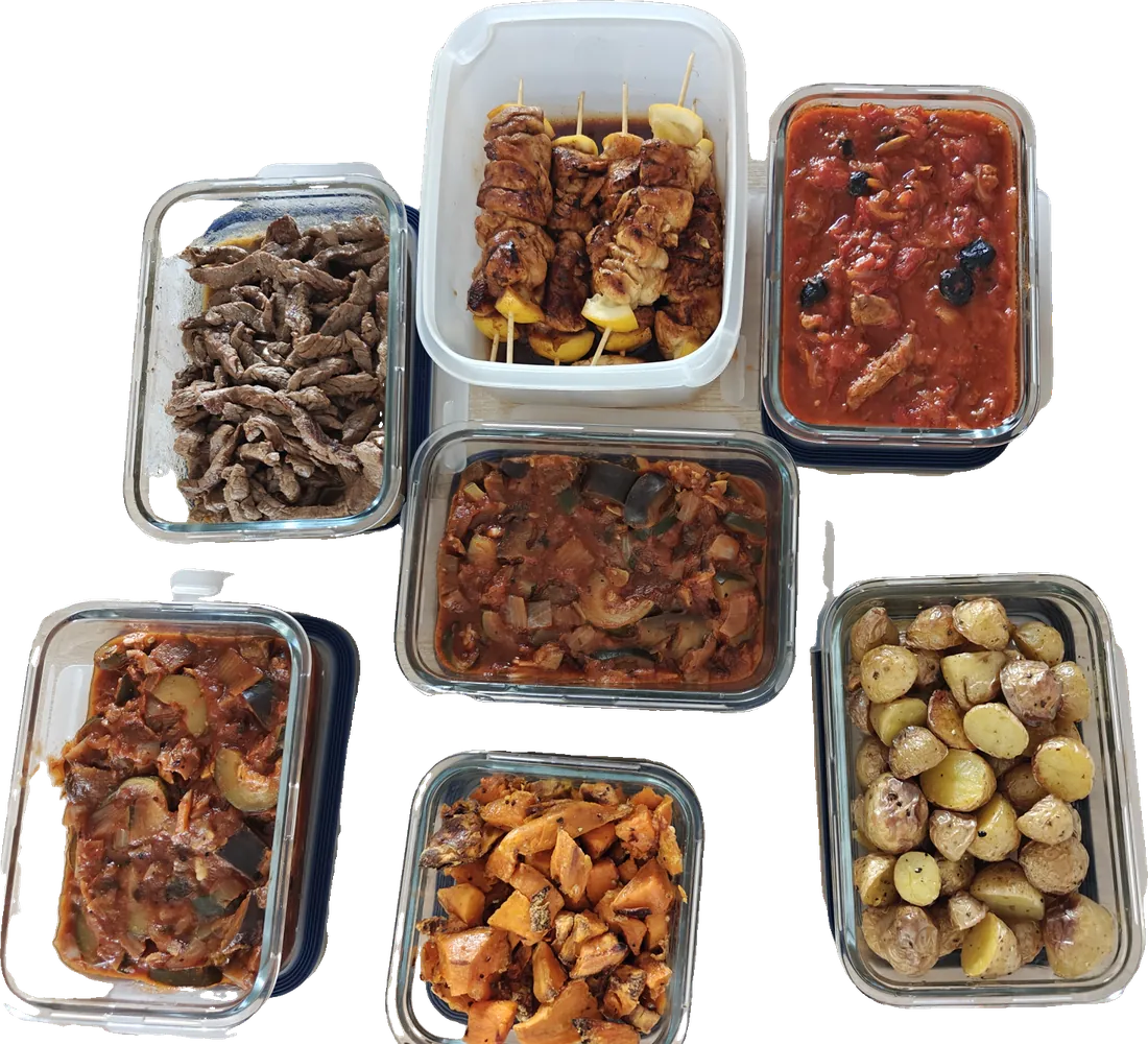 Boîtes en verre remplies de plats faits maison pour la semaine : brochettes, émincé de bœuf, légumes mijotés, patates douces et pommes de terre rôties